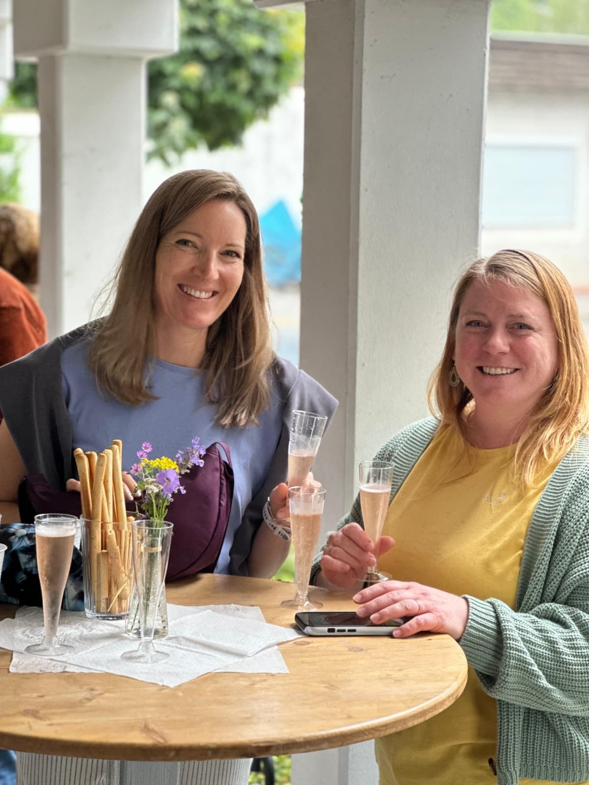 Zwei Frauen mit Prosecco am Stehtisch beim Dorfcafé